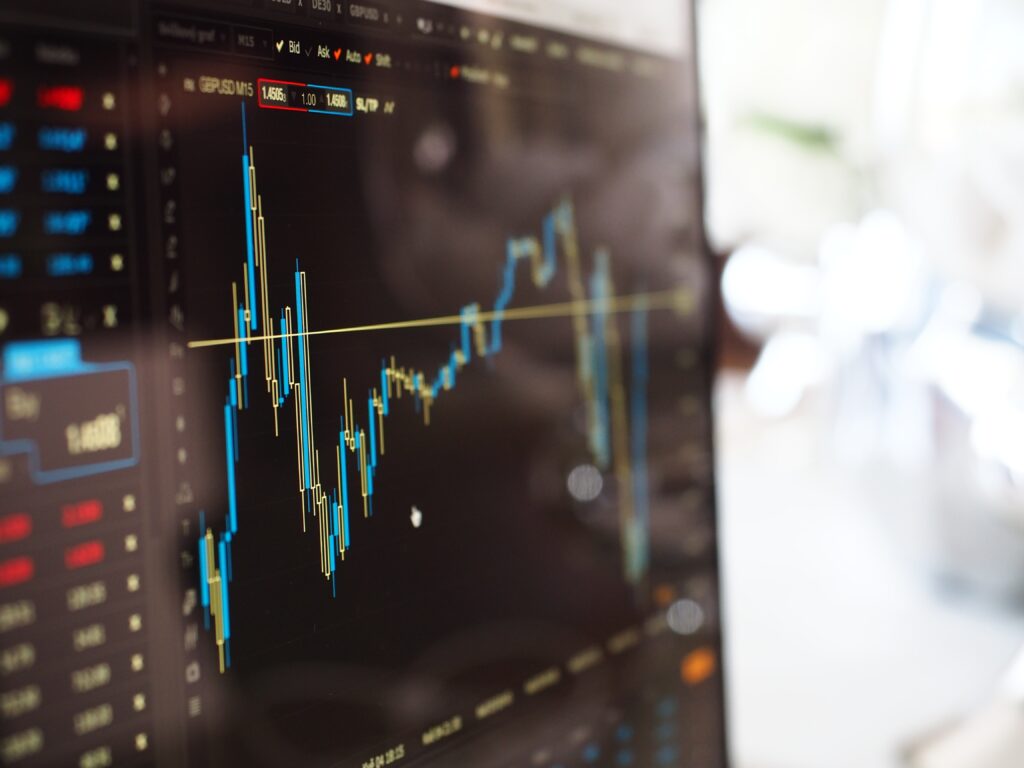 A close-up of a computer screen displaying a stock market candlestick chart with fluctuating prices.
