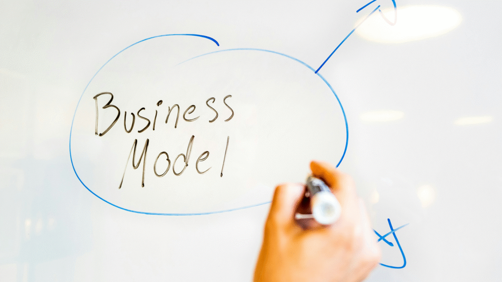 The words Business Model handwritten on a whiteboard, prominently circled, representing the strategic framework for how a company creates value and generates revenue.
