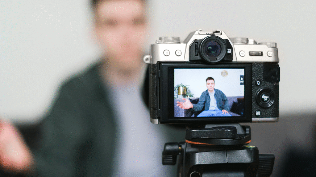 An influencer actively recording content, with their image visible on a camera screen, symbolizing the direct creation and connection central to influencer marketing and the modern creator economy.