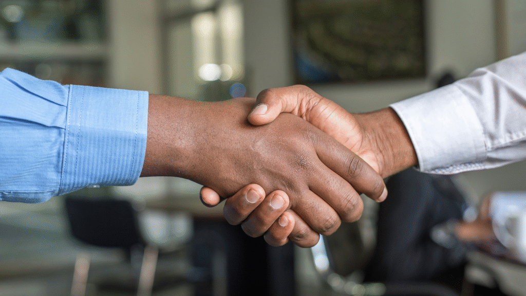 Two individuals shaking hands firmly, symbolizing a new connection, agreement, or partnership formed through effective networking.