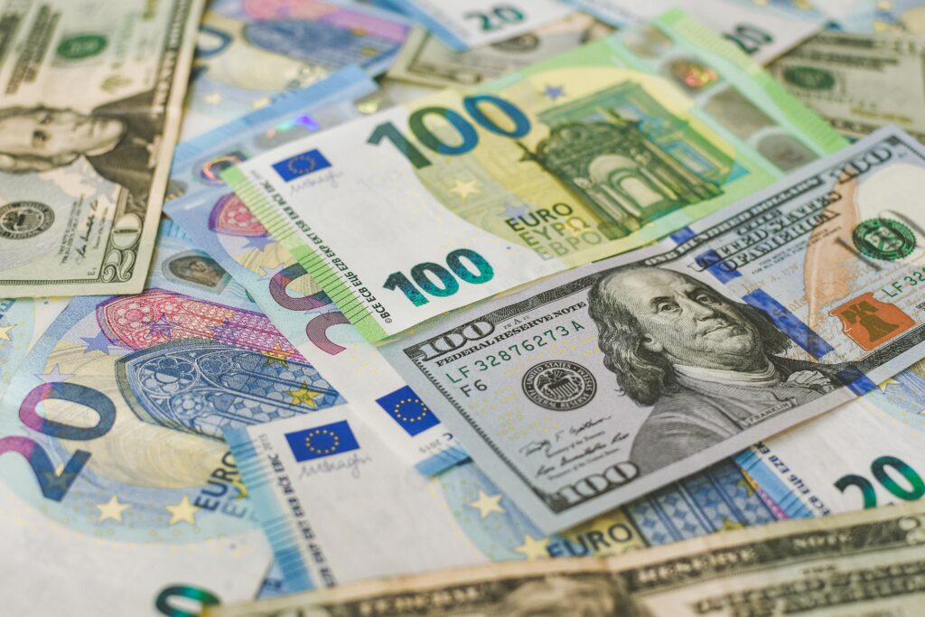 A scattered pile of international currency, including US dollars and Euros, showcasing economic diversity and financial transactions.