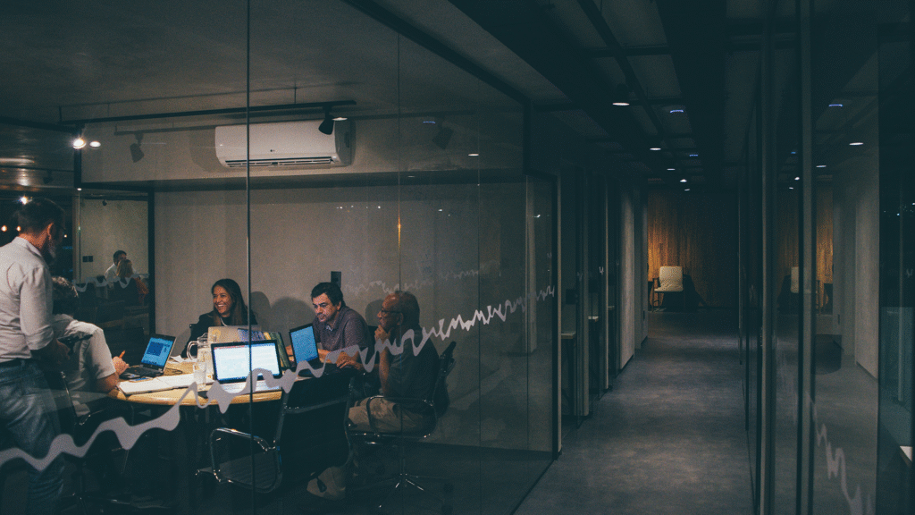 An external shot of a contemporary office interior, revealing people working in individual cabins or workspaces, symbolizing the collaborative yet focused environment common in modern startups.