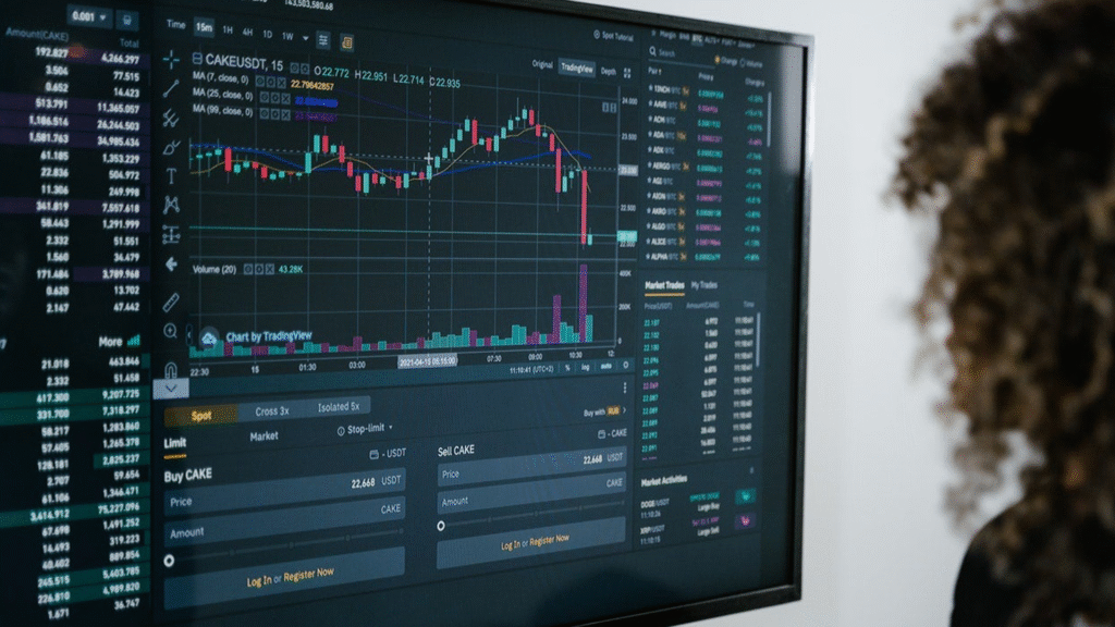 A person observing a digital trading terminal with charts showing financial data, symbolizing vigilance during stock market crashes.