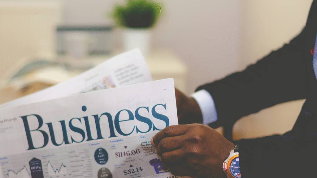 A professional in a business suit intently reading a business newspaper, symbolizing strategic planning and market awareness vital for a successful startup.