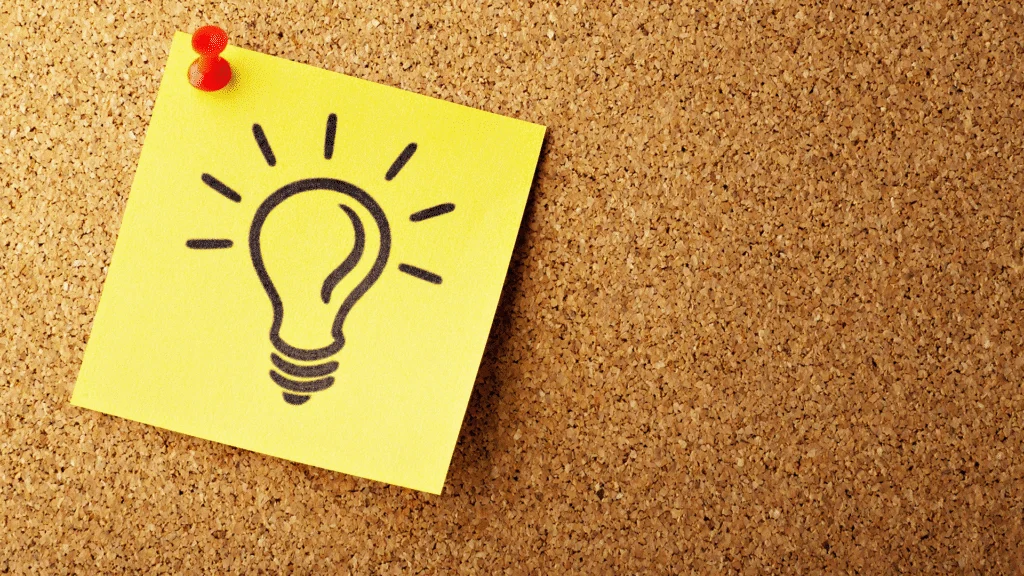 A yellow sticky note or paper affixed to a background, featuring a hand-drawn or stylized lightbulb, symbolizing the conceptualization and validation of a new business idea.