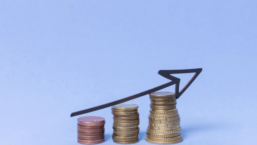 Pile of coins increasing in height with an upward arrow illustrating the growth of compound interest over time.