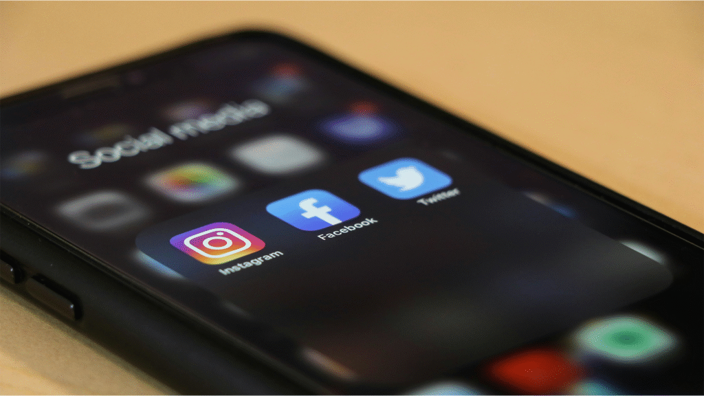 Smartphone screen displaying Instagram, Facebook, and Twitter apps representing social media marketing.