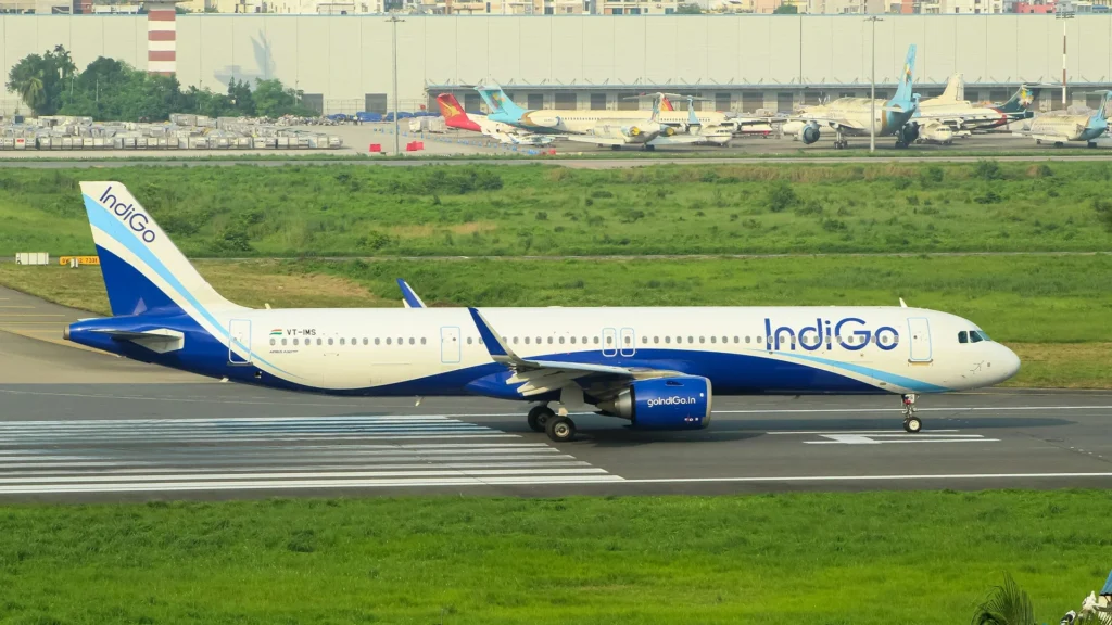 IndiGo Airbus A320 aircraft in distinctive blue and white livery taxiing on runway at Indian airport showing India's largest and most profitable airline
