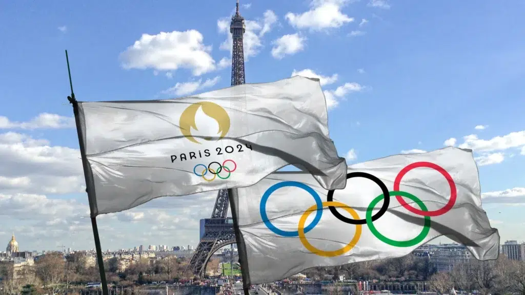 Paris 2024 Olympics flag waving with Eiffel Tower showcasing Olympic economics and host city costs