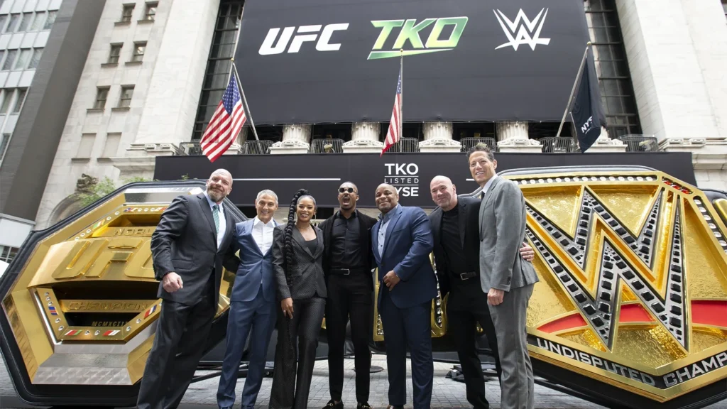 TKO Group Holdings executives at New York Stock Exchange including Dana White Ari Emanuel with UFC and WWE championship belts representing $21 billion WWE UFC merger September 2023 creating worlds largest combat sports company