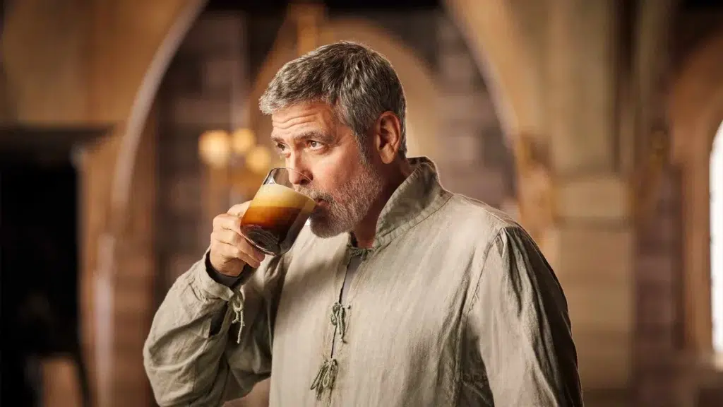 George Clooney enjoying Nespresso coffee in elegant setting showcasing premium coffee lifestyle and brand partnership