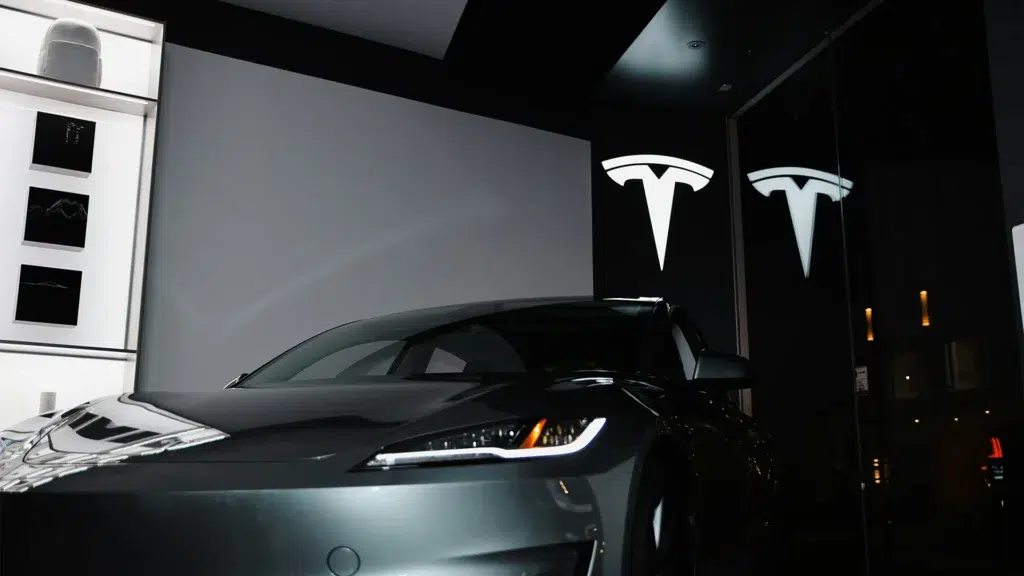 Tesla vehicle in modern showroom with Tesla logo branding on black walls