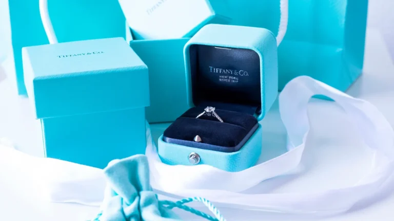 Tiffany & Co. signature blue box with white ribbon and engagement ring demonstrating brand's iconic packaging strategy and luxury positioning in jewelry market