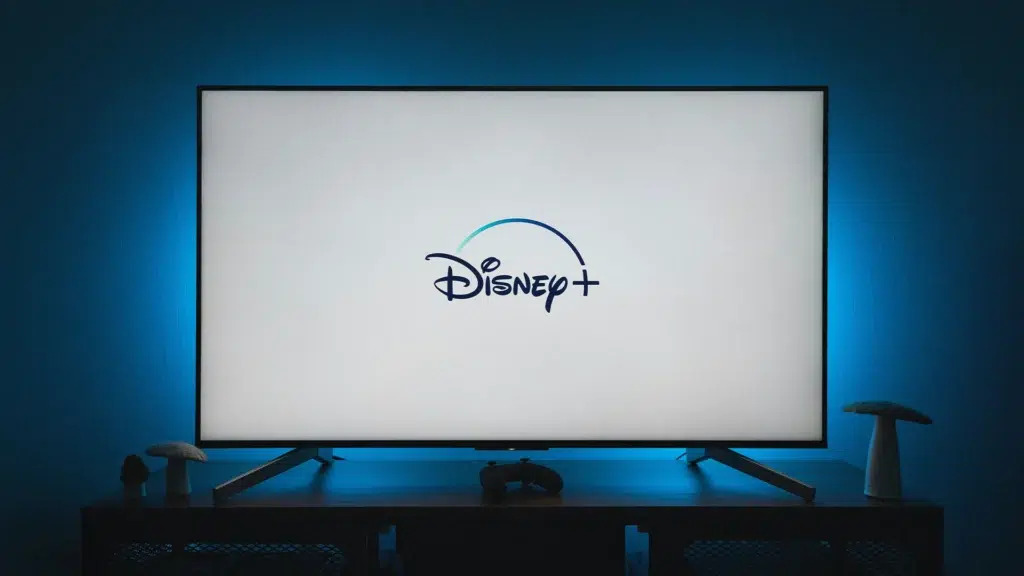 Disney Plus logo displayed on television screen in modern entertainment setup
