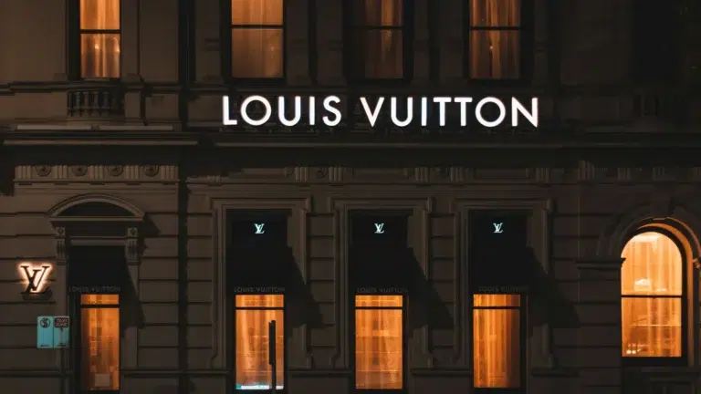 Louis Vuitton flagship store at night showing luxury brand retail demonstrating market dominance through accessibility and premium positioning