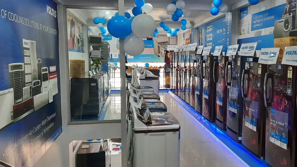 Voltas air conditioner showroom with blue branding displaying refrigerators and cooling products showing India's AC market leader retail strategy
