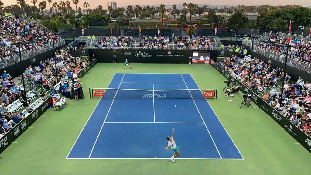 ATP 250 tournament match at packed stadium with Emirates sponsor boards ATP Tour net court USA tennis economics