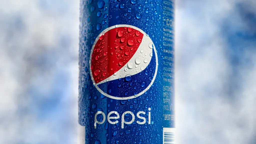 Pepsi cola can with water droplets against blue sky background representing the brand's global identity and cola wars history