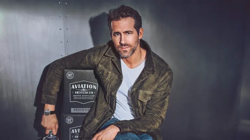 Ryan Reynolds posing with Aviation American Gin boxes, promoting the super-premium gin brand he co-owned before the $610 million Diageo acquisition