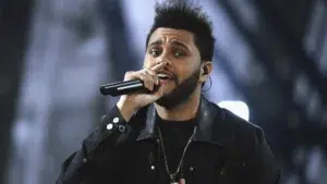 The Weeknd performing on stage in black leather jacket and cross necklace during Starboy era world tour show